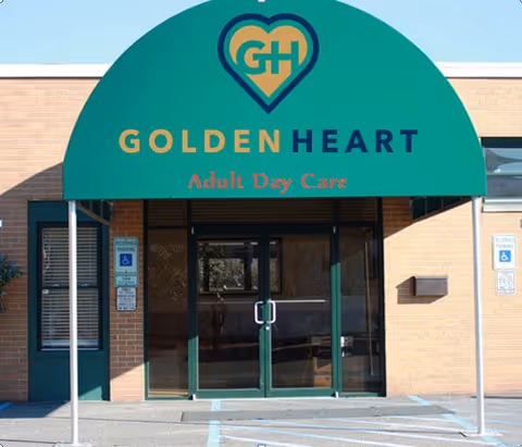 Entrance to Golden Heart Adult Day Care with a green awning and logo over glass double doors.