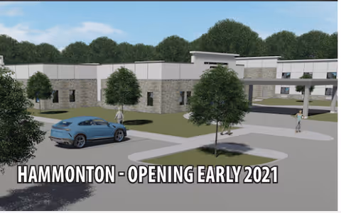 Rendering of the exterior of a senior living facility with a parking area, trees, and people walking near the entrance. Text overlay reads 'HAMMONTON - OPENING EARLY 2021'.