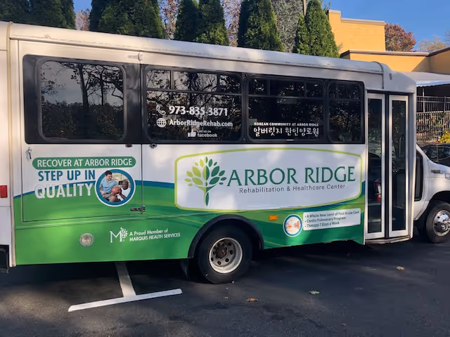 A green-and-white Arbor Ridge Rehabilitation & Healthcare Center shuttle bus parked outside, displaying the facility's logo, contact information, and slogan.