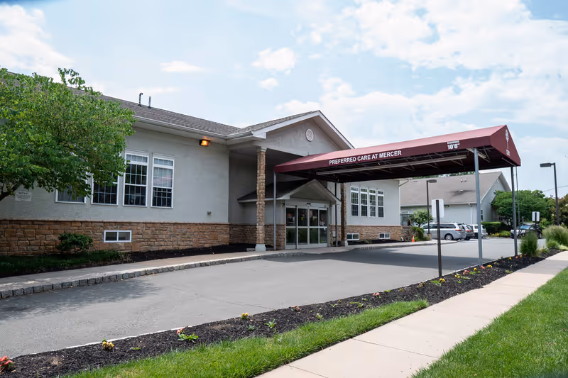 Front entrance of Preferred Care at Mercer showing a covered maroon canopy over the driveway and the building façade.