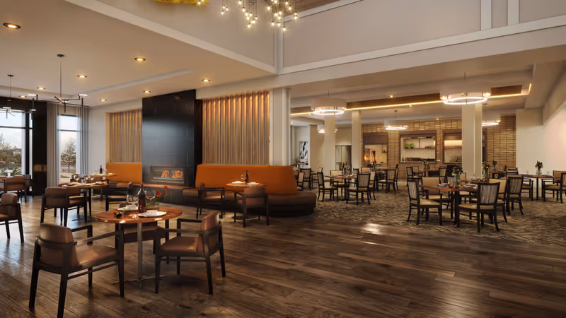 Spacious dining room with round wooden tables, upholstered chairs and booths, a fireplace, and warm pendant lighting.